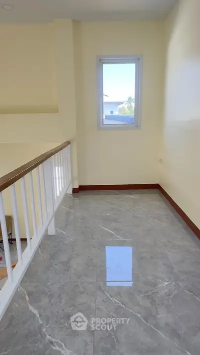 Bright hallway with marble flooring and a window view