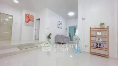 Spacious modern living room with sleek white interiors and cozy seating area.