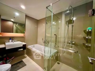 Modern bathroom with glass shower and bathtub in luxury apartment