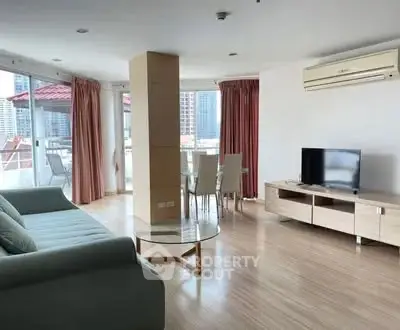 Spacious living room with modern furniture and large windows offering city views.