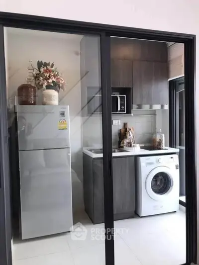 Modern kitchen with sleek appliances and stylish cabinetry in a compact layout.