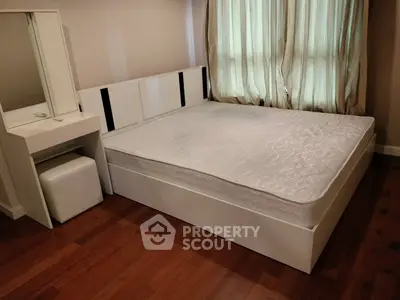 Modern bedroom with sleek white furniture and wooden flooring