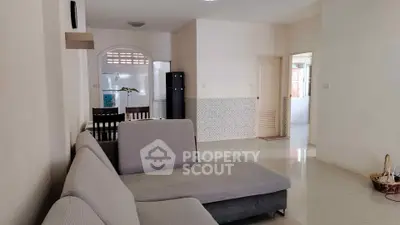 Spacious living room with modern gray sofa and dining area in open layout.