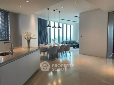 Luxurious open-plan kitchen and dining area with elegant decor and city view.