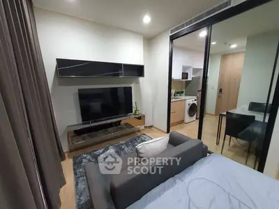 Modern studio apartment with sleek interior design, featuring a cozy living area and a compact kitchen.