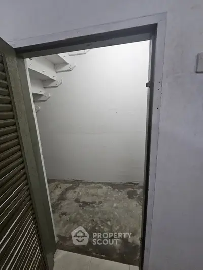 Spacious storage room with concrete floor and white walls, ideal for organizing household items.