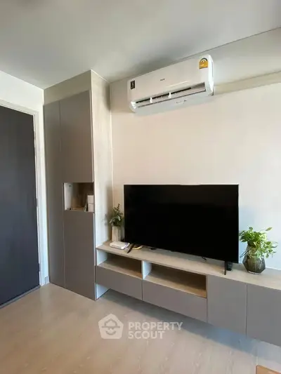 Modern living room with sleek TV unit and air conditioning, perfect for cozy entertainment.