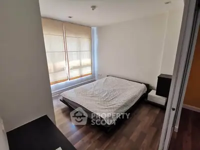Spacious bedroom with modern decor and large windows for natural light.