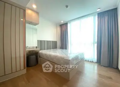 Modern bedroom with large window and stylish decor in a contemporary apartment.