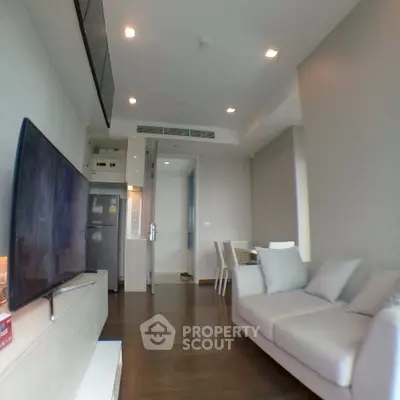 Modern living room with sleek furniture and open kitchen layout in a stylish apartment.
