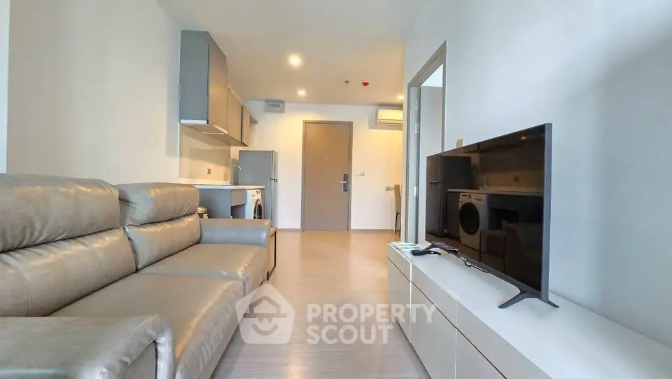 Modern living room with sleek furniture and open kitchen layout in a stylish apartment.