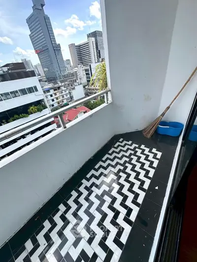 Chic urban balcony with stunning cityscape views and stylish black-and-white zigzag flooring.