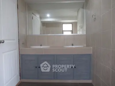 Spacious bathroom with dual sinks and large mirror, perfect for modern living.