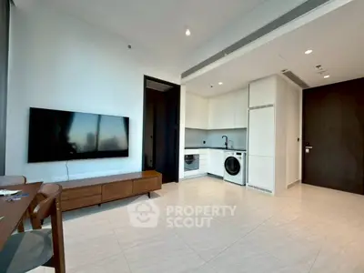 Modern living room with sleek kitchen and large TV, perfect for urban living.