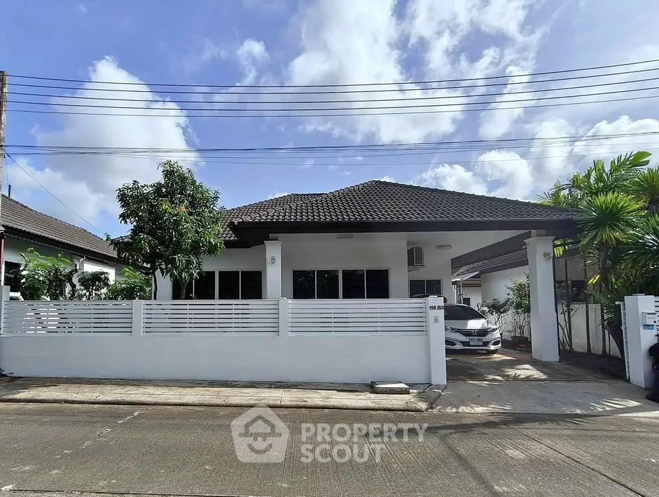Charming single-story house with a carport and lush greenery in a serene neighborhood.