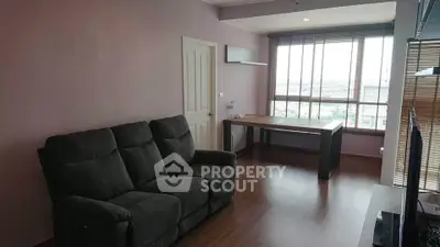 Modern living room with large window and stylish furniture, offering a bright and inviting atmosphere.