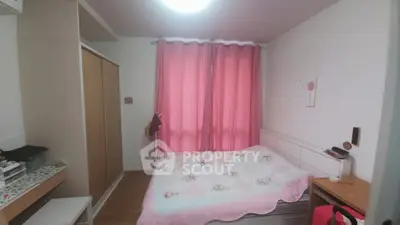 Cozy bedroom with pink curtains and floral bedding in modern apartment.