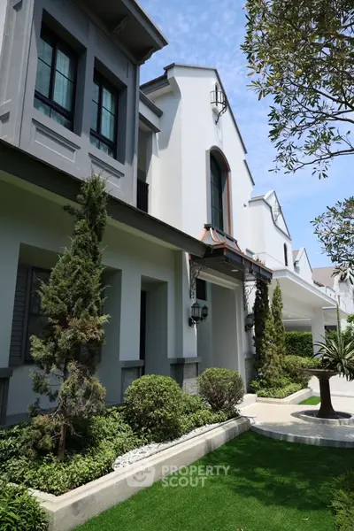 Elegant modern house exterior with lush landscaping and stylish architectural design.