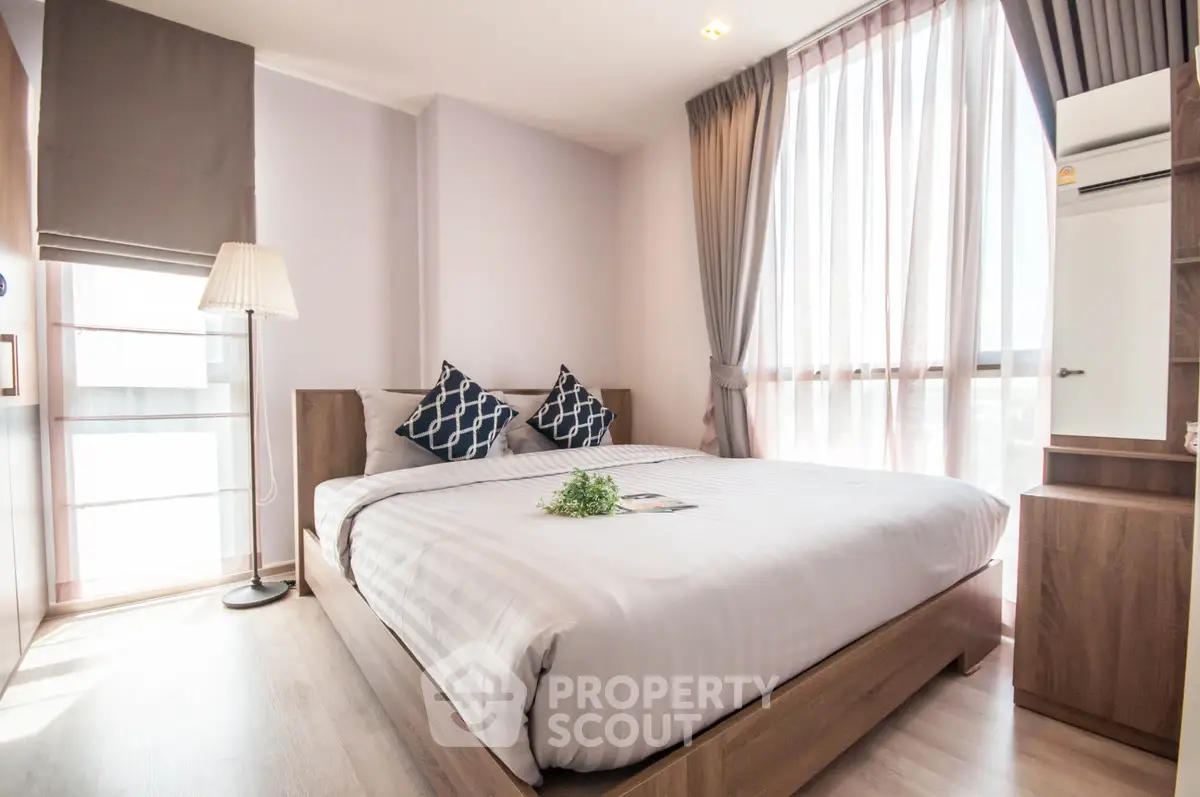 Bright and cozy bedroom with modern decor and large windows.