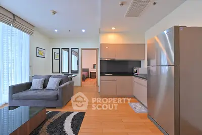 Modern open-plan living room with sleek kitchen and cozy seating area.