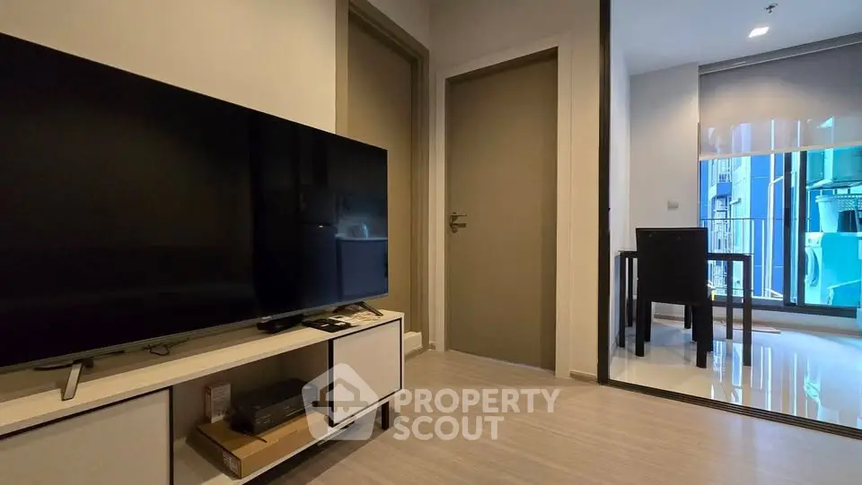 Modern living room with sleek TV setup and dining area in stylish apartment