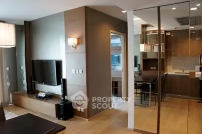 Modern living room with sleek design and open layout, featuring a wall-mounted TV and stylish lighting.
