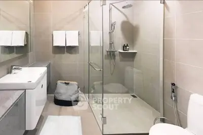 Modern bathroom with glass shower and sleek fixtures in a contemporary home.