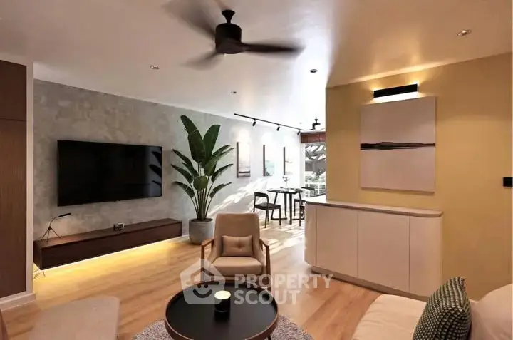 Modern living room with stylish decor and open layout, featuring a large TV and elegant lighting.