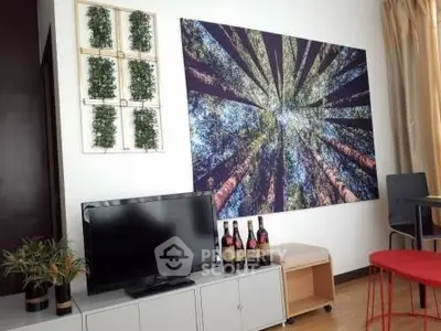 Modern living room with stylish decor and wall art, featuring a TV and comfortable seating area.
