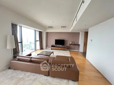 Spacious modern living room with panoramic city views and elegant leather sofa.
