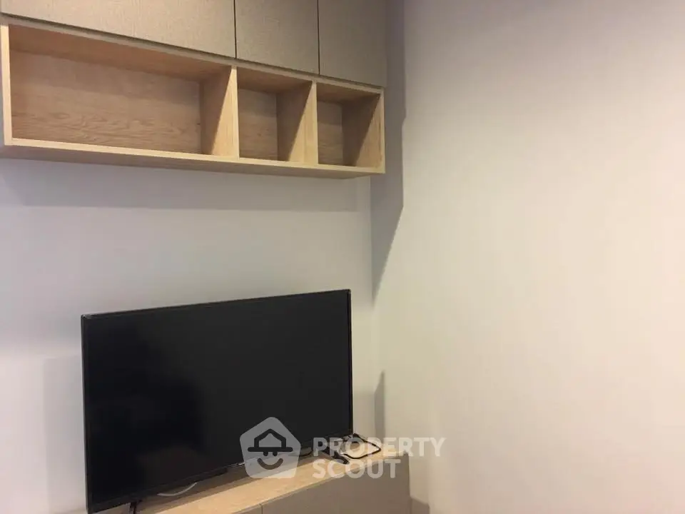 Modern living room with sleek TV setup and stylish shelving unit.