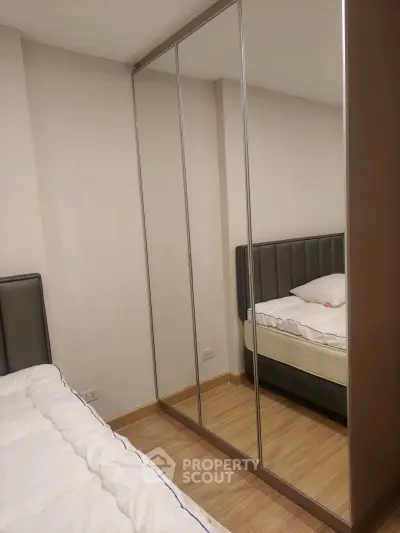 Modern bedroom with mirrored wardrobe and cozy bed in stylish apartment