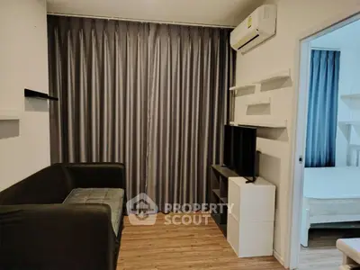 Cozy living room with modern decor and air conditioning, adjacent to a bedroom.