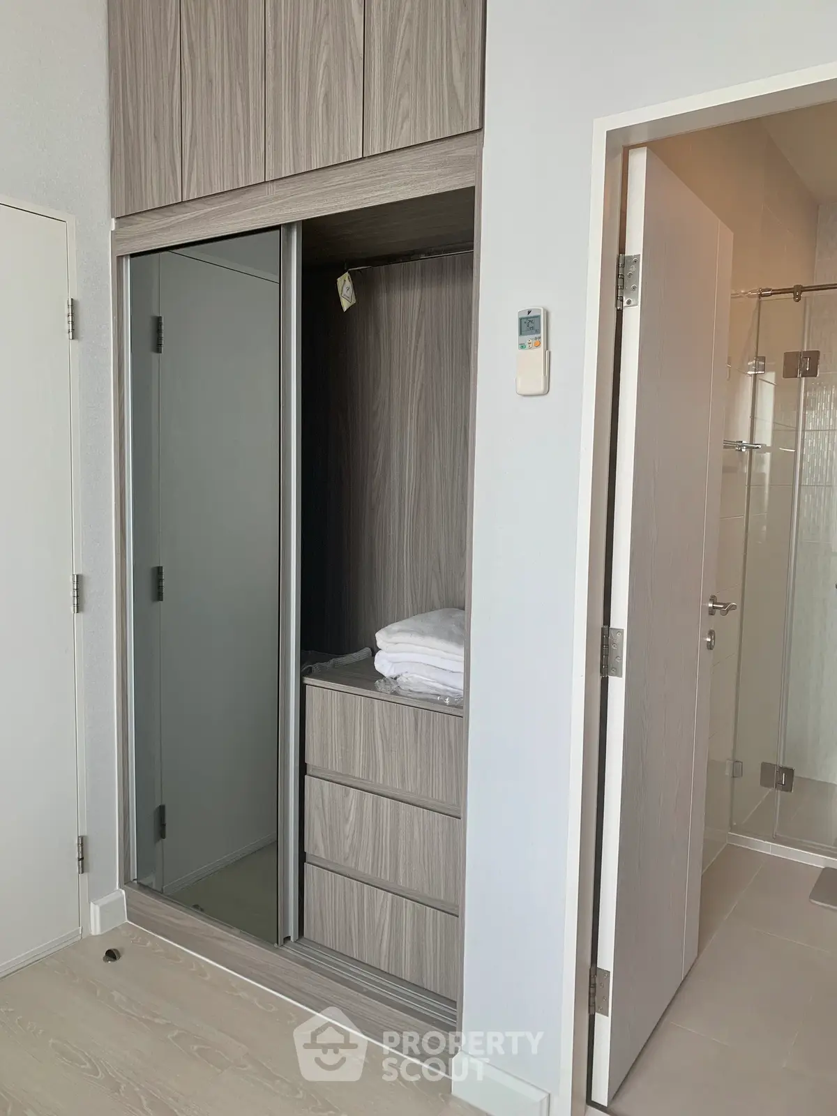 Modern bedroom with built-in closet and bathroom access, featuring sleek design and ample storage space.