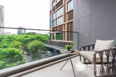 Modern balcony with glass railing and city view, featuring stylish outdoor furniture.