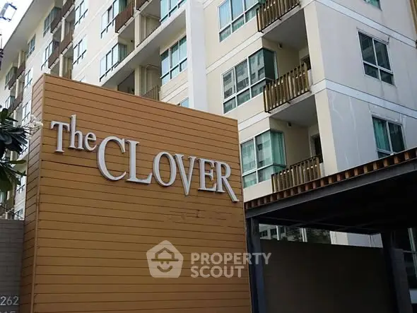 Modern apartment building exterior with The Clover sign, showcasing urban living.