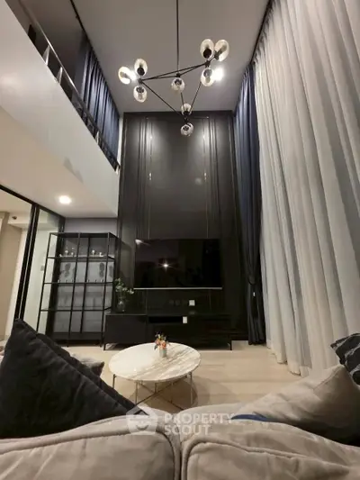 Luxurious modern living room with high ceilings and elegant chandelier