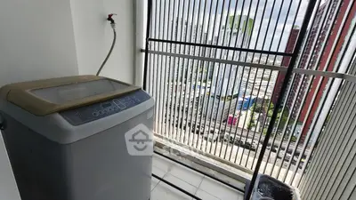 High-rise apartment balcony with washing machine and city view