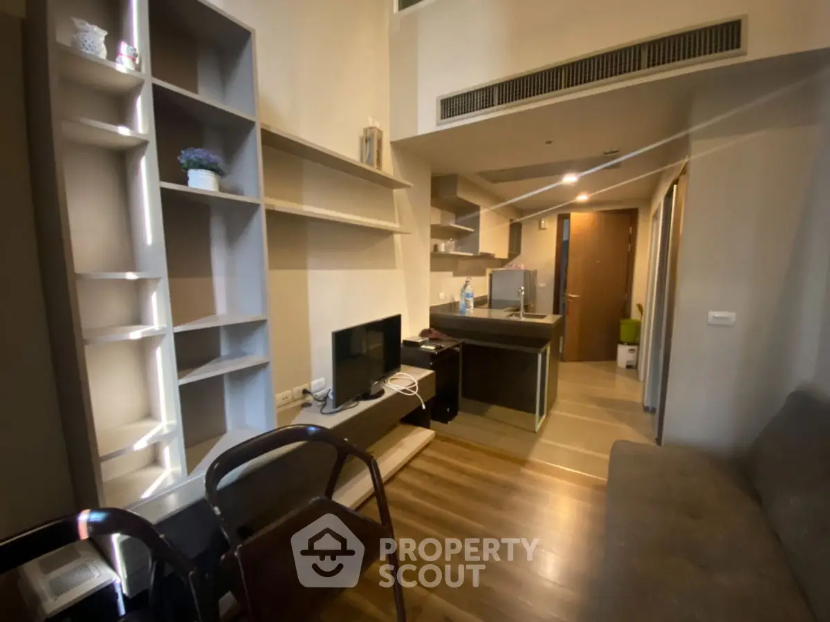 Modern living room with open kitchen layout and stylish shelving