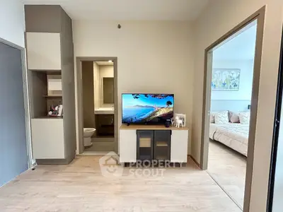 Modern apartment interior with open layout, featuring a cozy living area and a glimpse into a stylish bedroom.