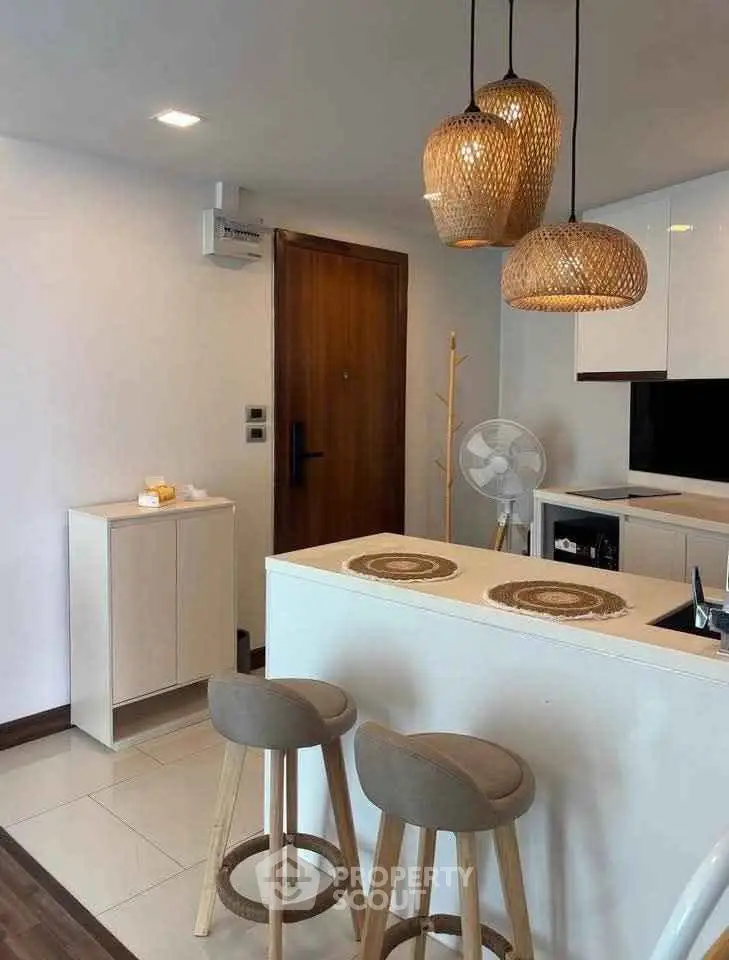 Modern kitchen with stylish pendant lights and breakfast bar seating