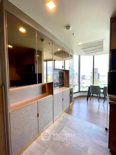 Modern kitchen with open layout and stunning city view, featuring sleek cabinetry and dining area.