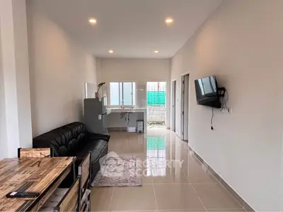 Modern living room with sleek furniture and wall-mounted TV in a bright, open space.
