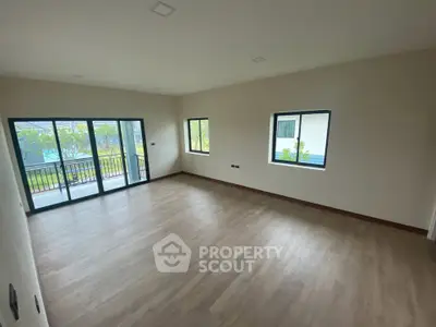 Spacious empty room with large windows and balcony access, perfect for customization.