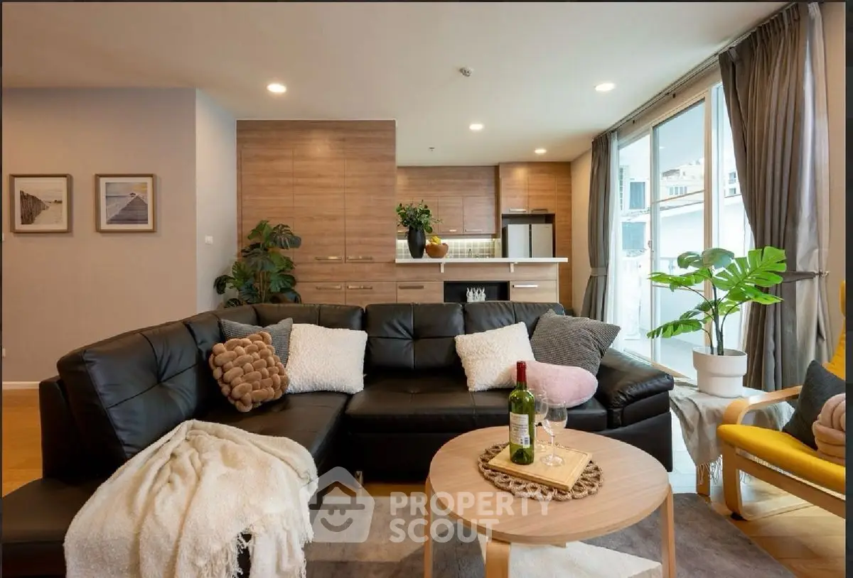 Stylish modern living room with cozy sectional sofa and open kitchen layout.
