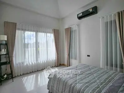 Spacious bedroom with large windows and modern decor