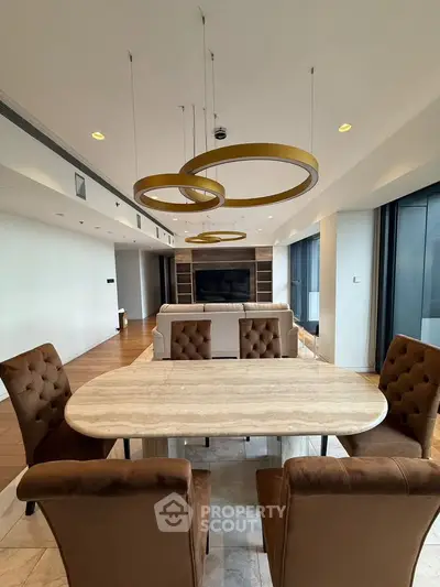 Luxurious open-plan living and dining area with modern lighting and elegant furnishings.