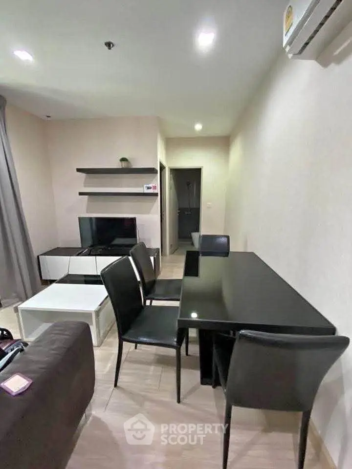 Modern living room with sleek black dining table and wall-mounted TV, perfect for urban living.