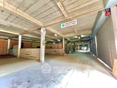 Spacious industrial warehouse with safety signage and ample storage space