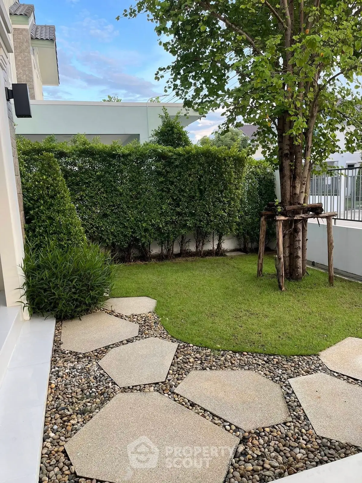 Charming garden with lush greenery and stone pathway in modern residential property.